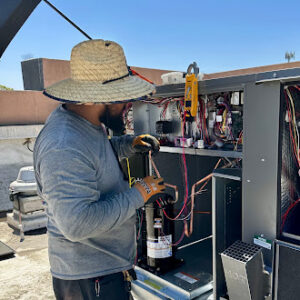 Technician verifying specs on a large commercial rooftop unit.